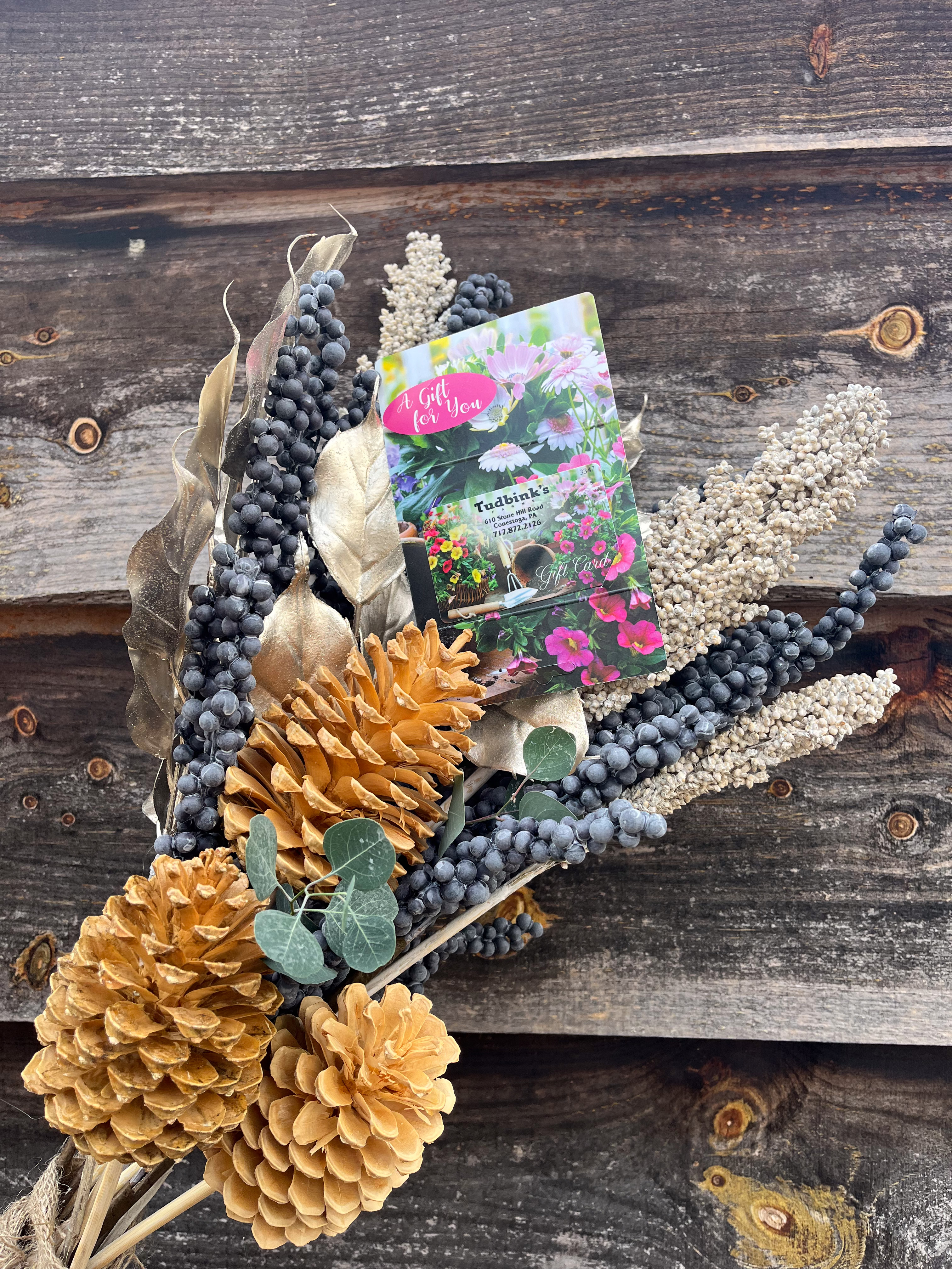 Pine cones and berry branches arrangement with a Tudbink's Farm gift card