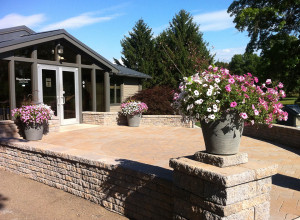 three commercial planters with pink and white flowers