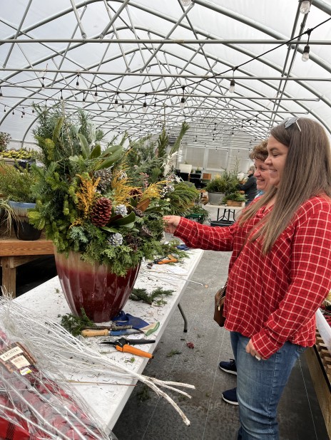 2 people building large winter planters inside a greenhouse.